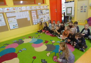 Grupa dzieci ogląda film edukacyjny na tablicy interaktywnej.